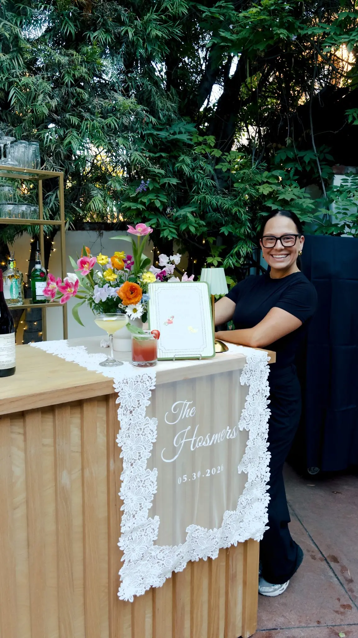 Taylor behind a garden bar she styled with spring florals and cocktails